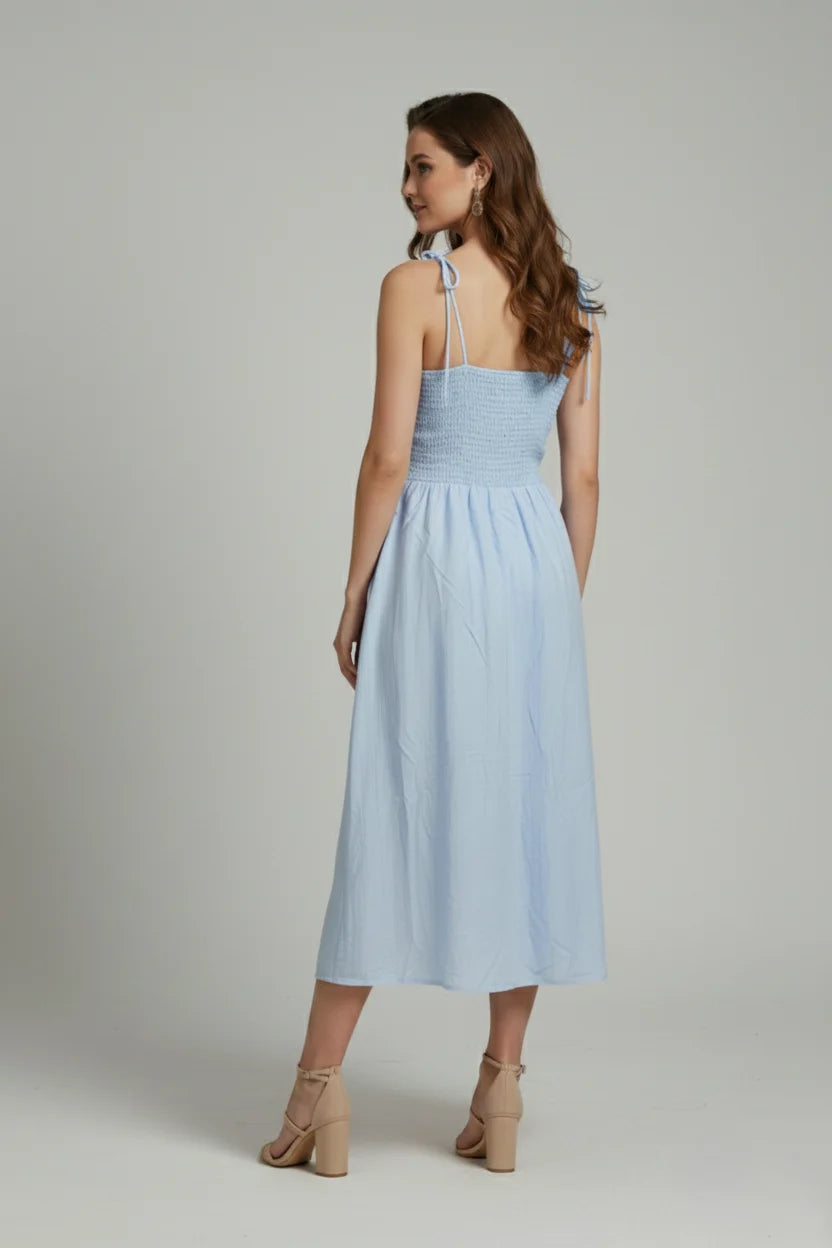 This midi length dress features shoulder tie straps and a flattering silhouette for a soft, classy feminine style.