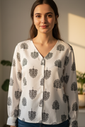 This sophisticated white shirt for women features a flattering V-neckline and intricate black floral motifs. A perfect floral shirt for women that combines modern style with classic elegance.